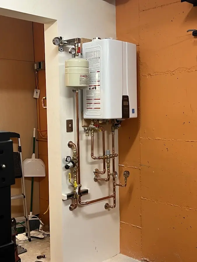 Plumbing technician inspecting water heater connections in Mission Bend